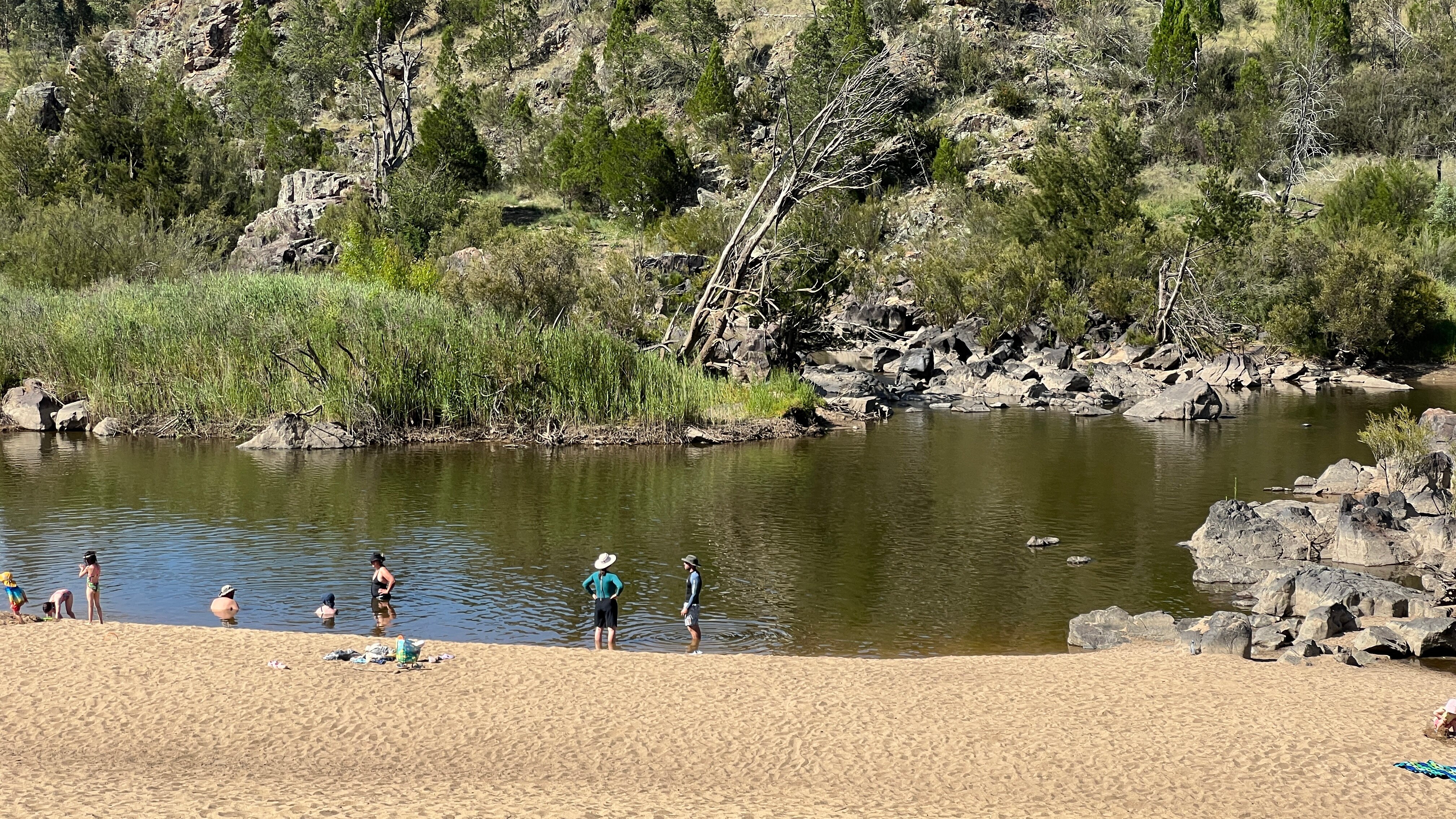 a group of swimmers paddling in a shallow river