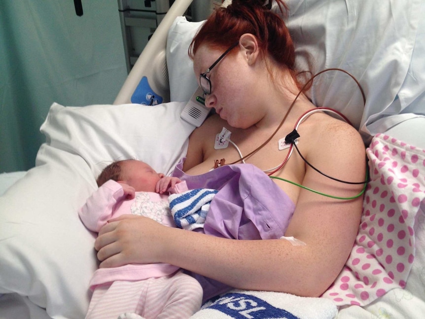 Mother Jessica Linwood attached to medical equipment asleep with her daughter Harper on her chest.