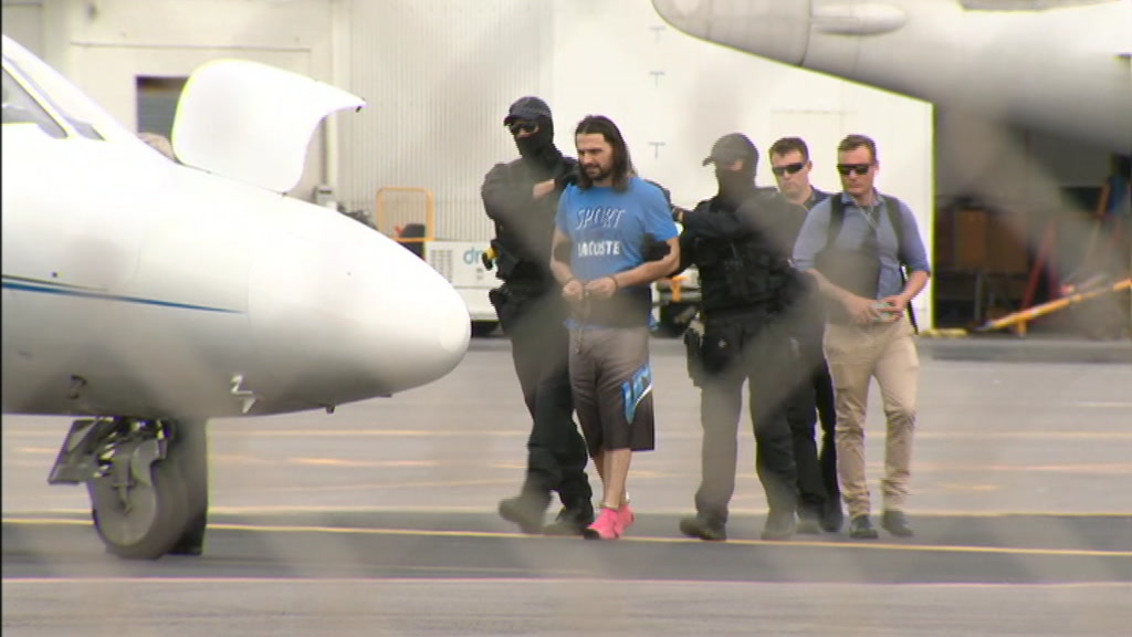 Terror-accused in custody being led onto a plane.