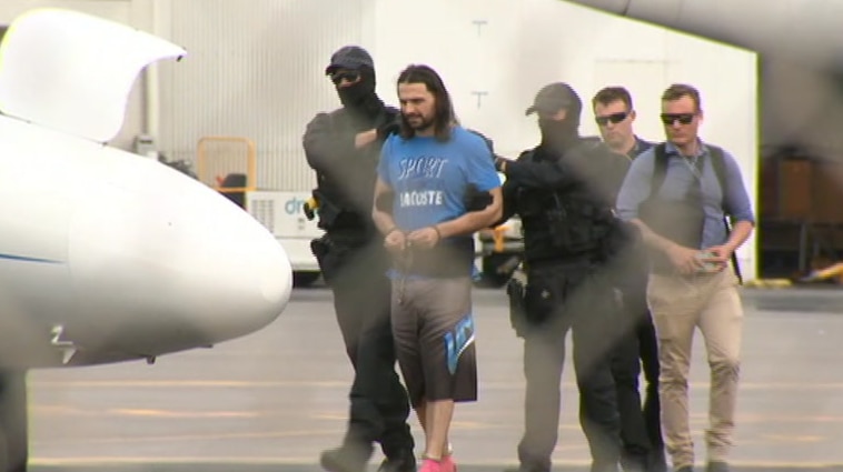 Terror-accused in custody being led onto a plane.