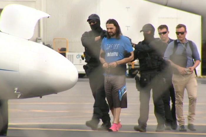 Terror-accused in custody being led onto a plane.