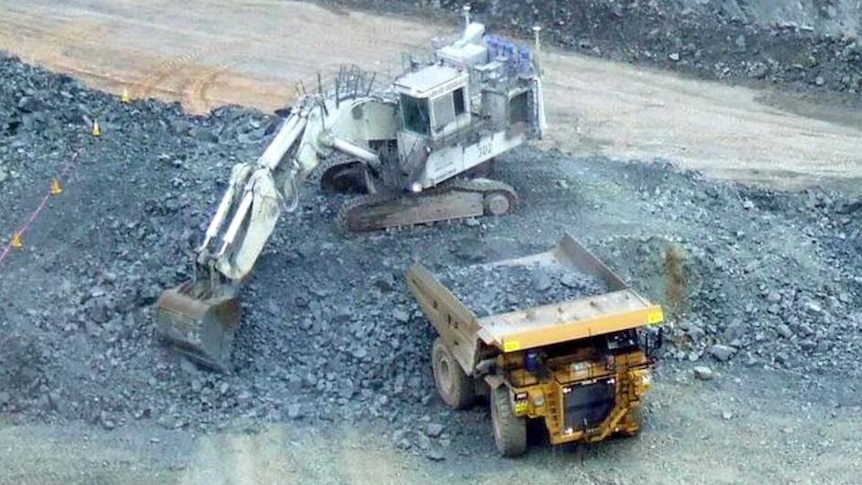 Earthmovers excavate at a mine site.