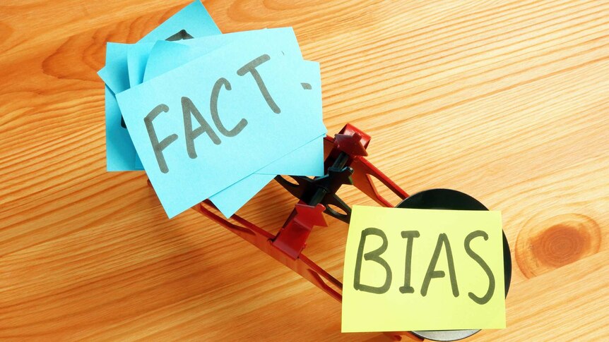 Pair of scales weighing fact against bias