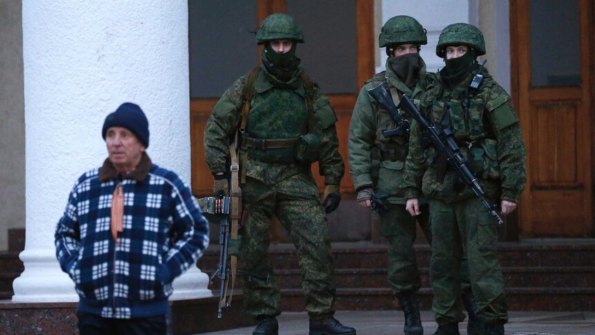 Armed men patrol at the airport in Simferopol, Ukraine