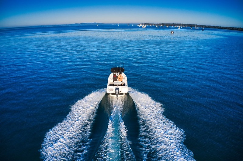 A boat in open water with two men on it.