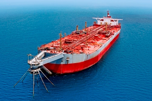 A red and white oil tanker in the ocean