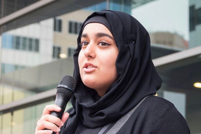 Doha Khan holds a microphone