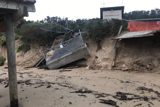 A collapsed concrete structure has fallen down a steep sand dune in front of the Wye River Surf Club.