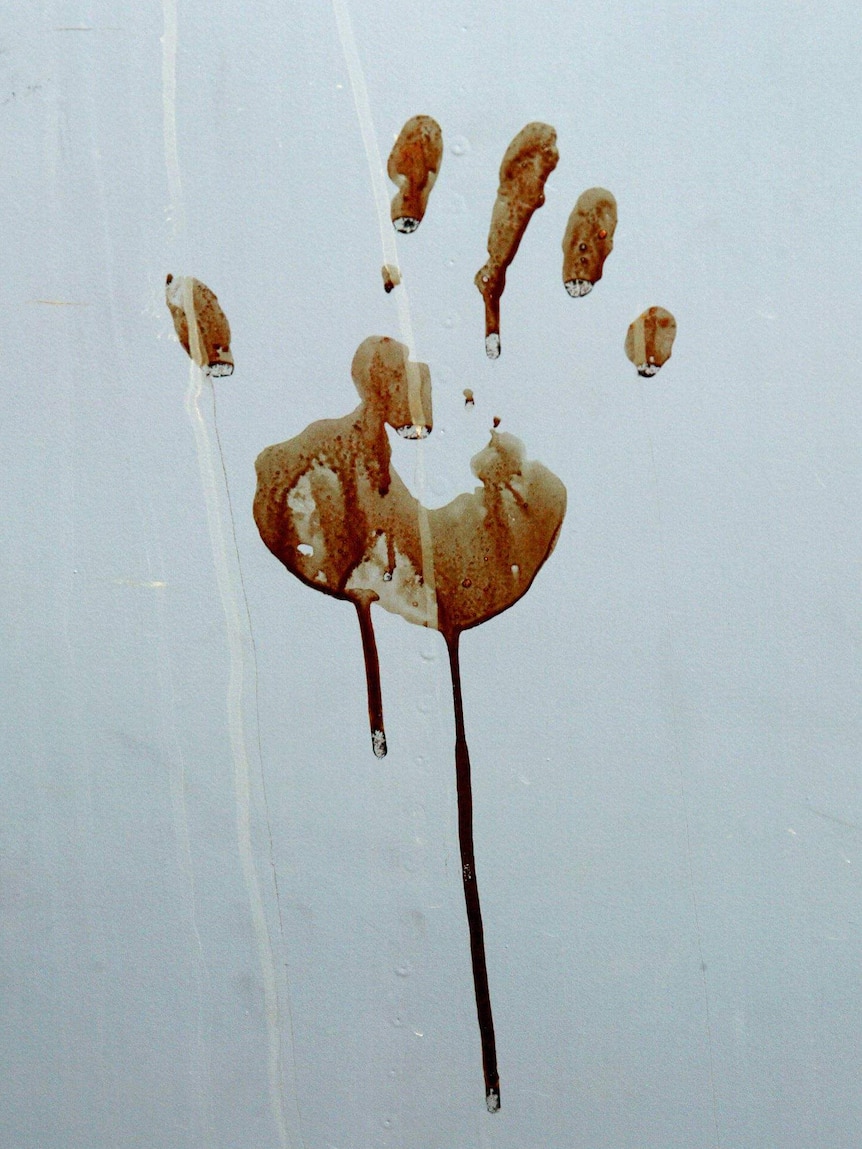 A bloody handprint, dripping, against a white/grey background/