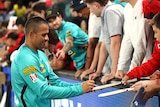 Brisbane Heat player Usman Khawaja signs autographs for fans after a game against Melbourne Renegades.