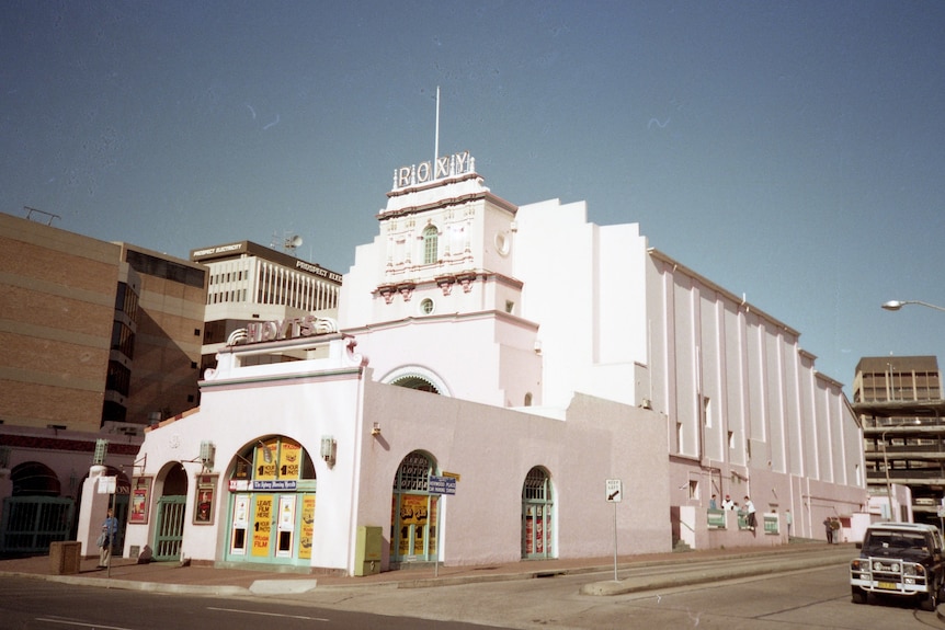 A grand 1930s white theatre with the word Roxy at the top.