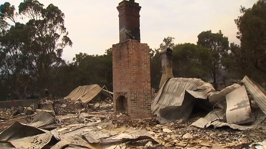 A chimney stands amid the rubble of destroyed buildings in Yarloop.
