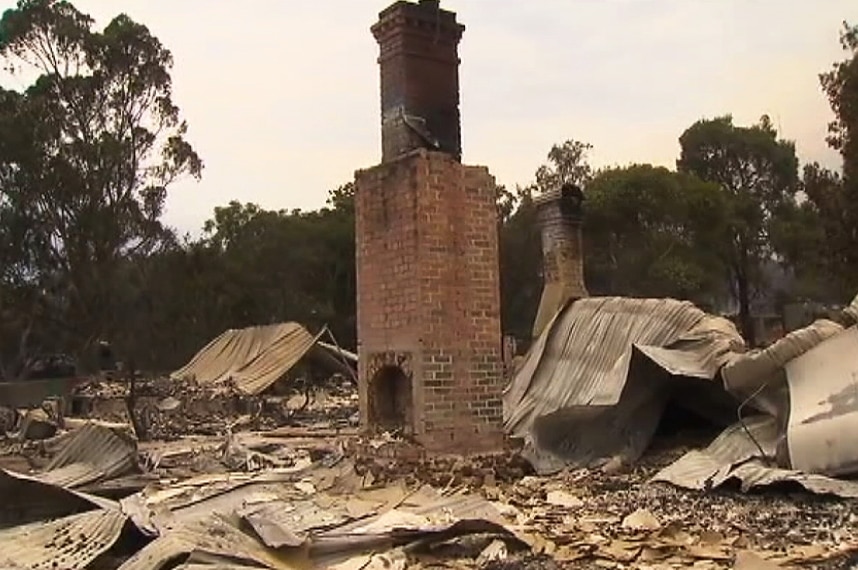 A chimney stands amid the rubble of destroyed buildings in Yarloop.