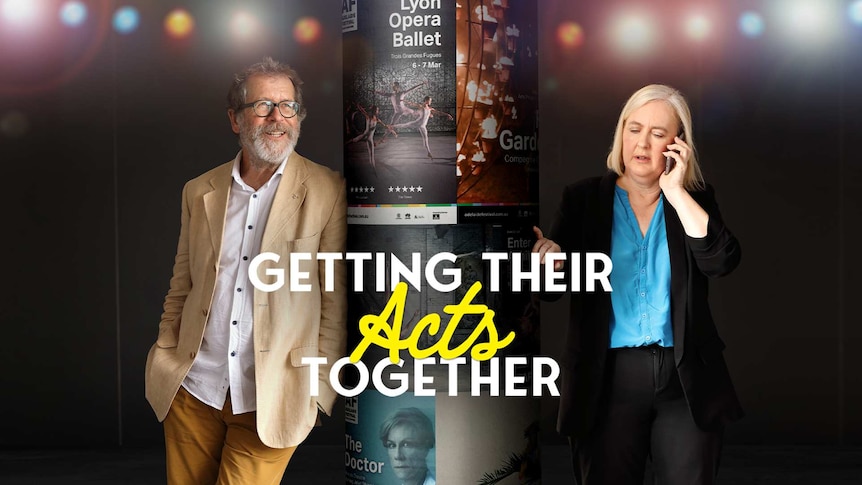 Two festival directors standing beside a pole with posters printed and stuck to it