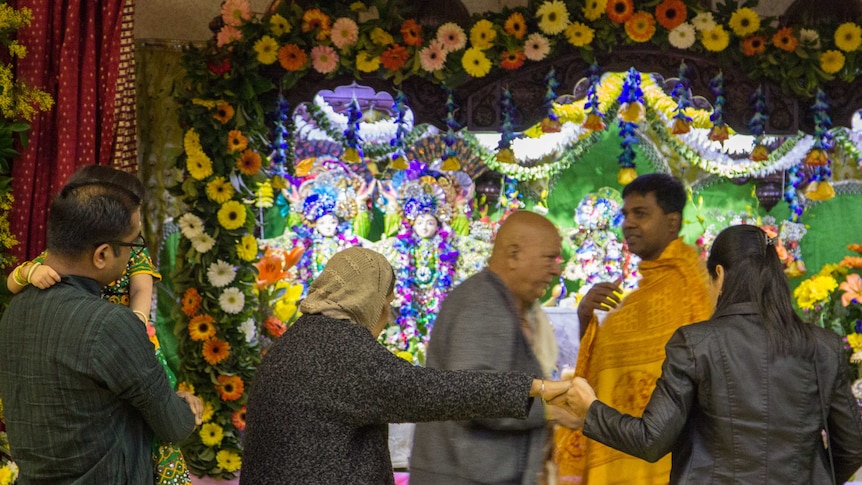 People line up to make their offerings at the temple on Krishna's birthday.