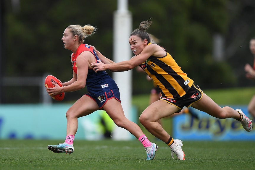 Emily Bates of Hawthorn tackles Tyla Hanks of the Demons