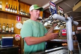 Man pours beer at pub bar