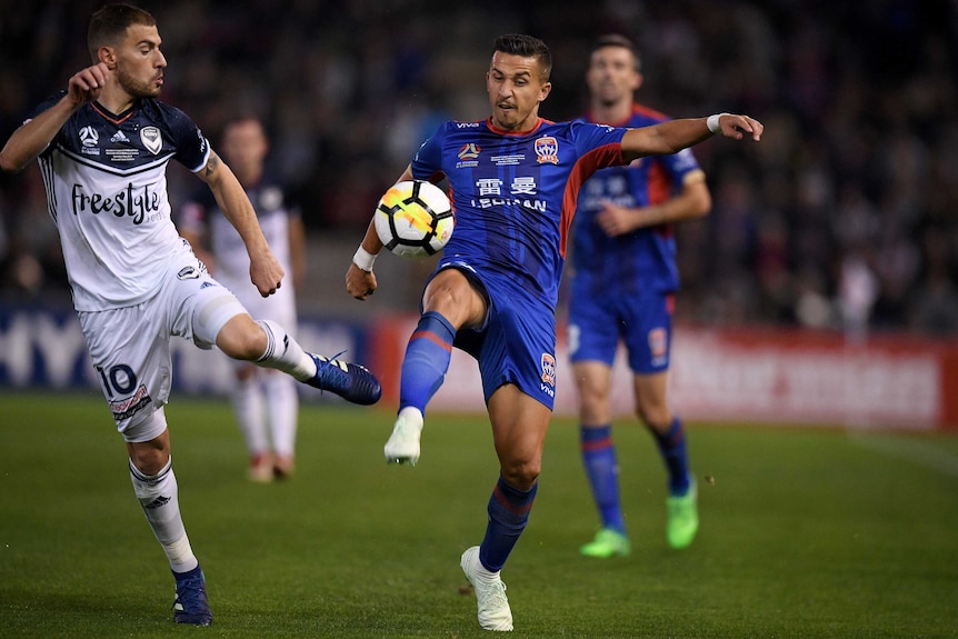 Daniel Georgievski and James Troisi contest for the ball in the A-League grand final.