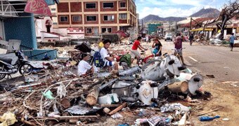 People sit on debris in Tacloban city