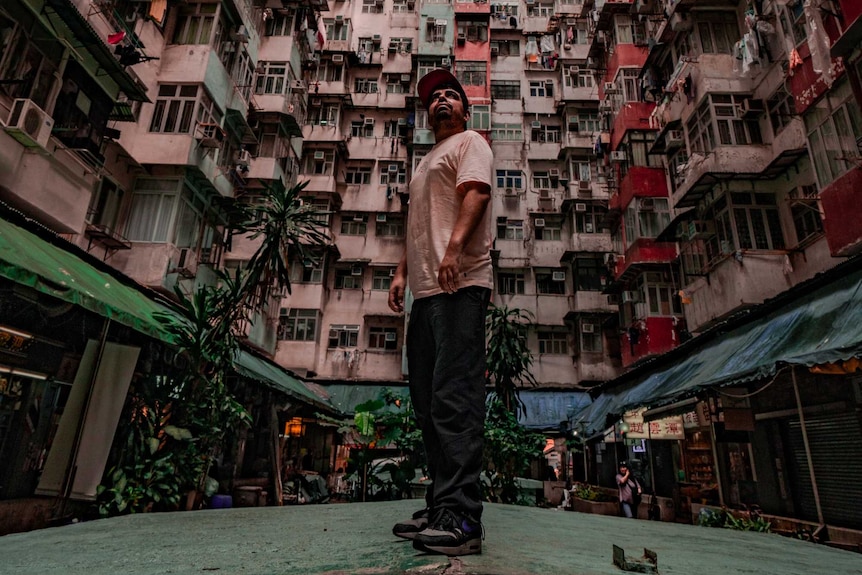 A man stands in front of a towering apartment lock