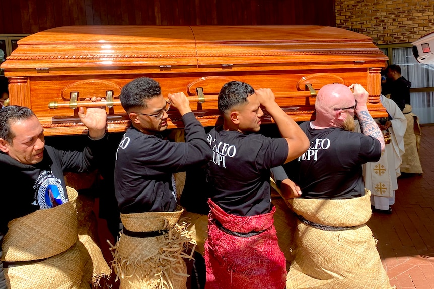 Men carry casket into car