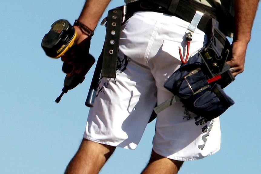 A tradesman works on the roof of a new house construction