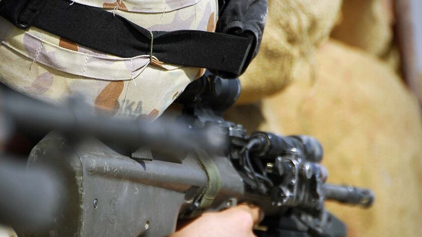 An Australian soldier looks through his gun sight