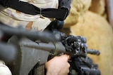 An Australian soldier looks through his gun sight