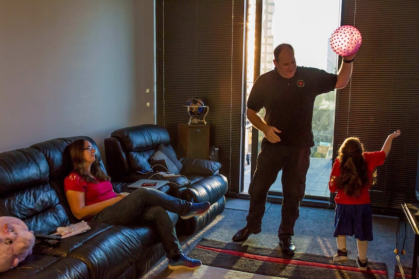 Rodney McMurtrie plays ball with his daughter Chloe in their Southbank apartment.