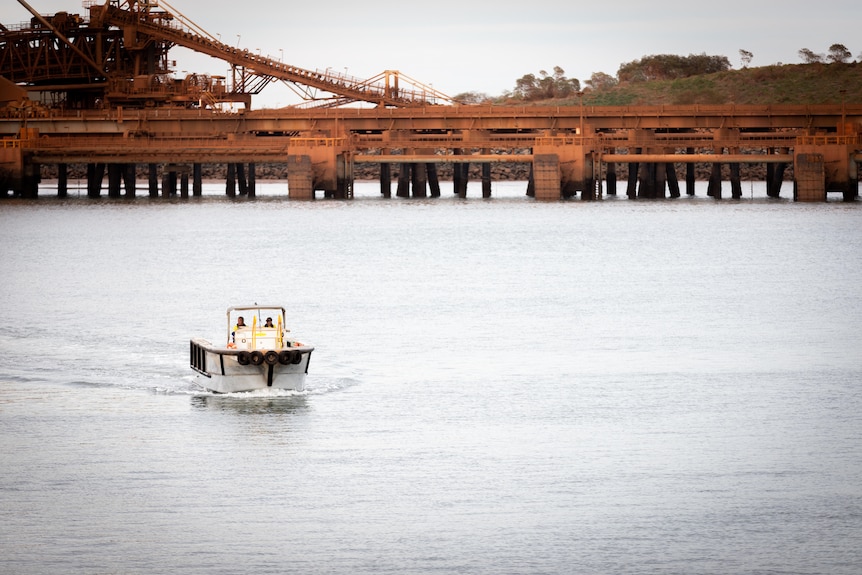A small boat sails through the harbour in Port Hedland.