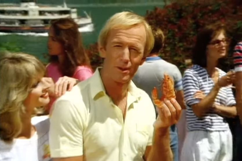 Paul Hogan holding a shrimp.