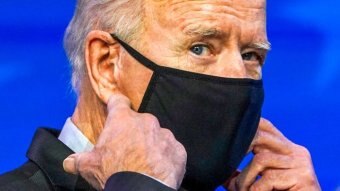 Joe Biden adjusting a black face mask