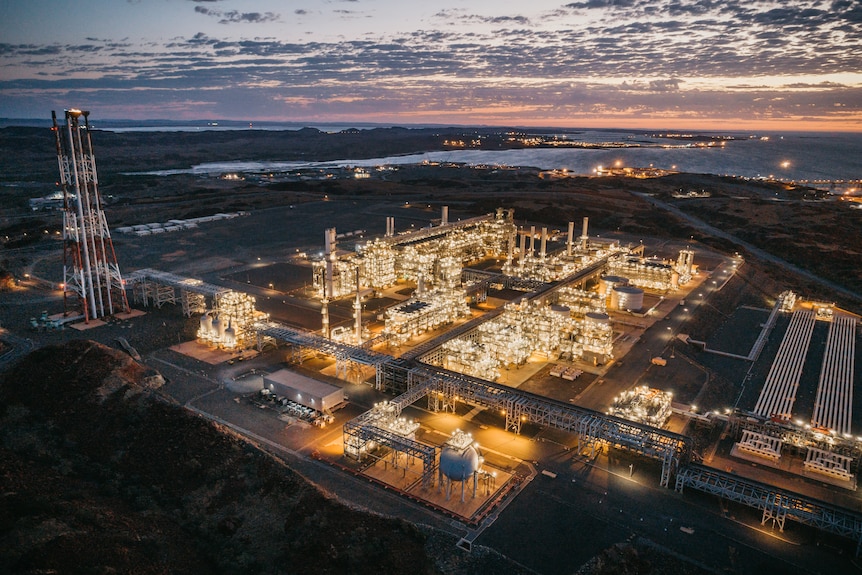 A large mining hub lit up with lights at dusk.