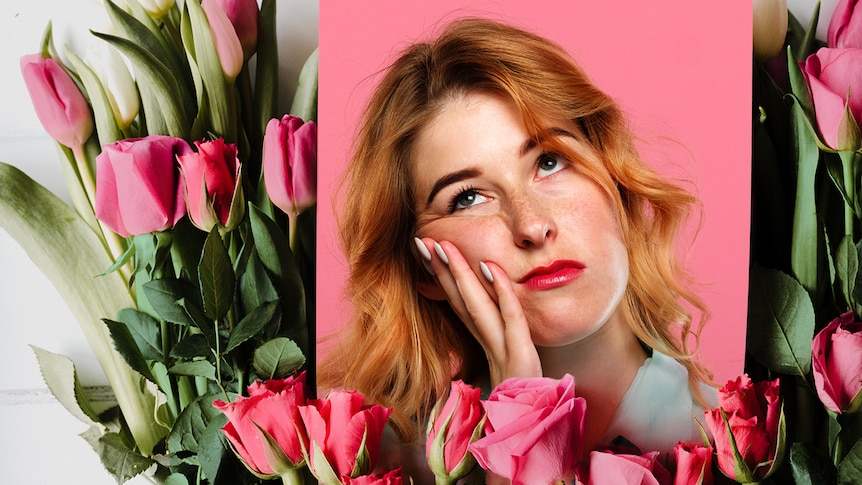 Bored-looking woman against a backdrop of flowers.