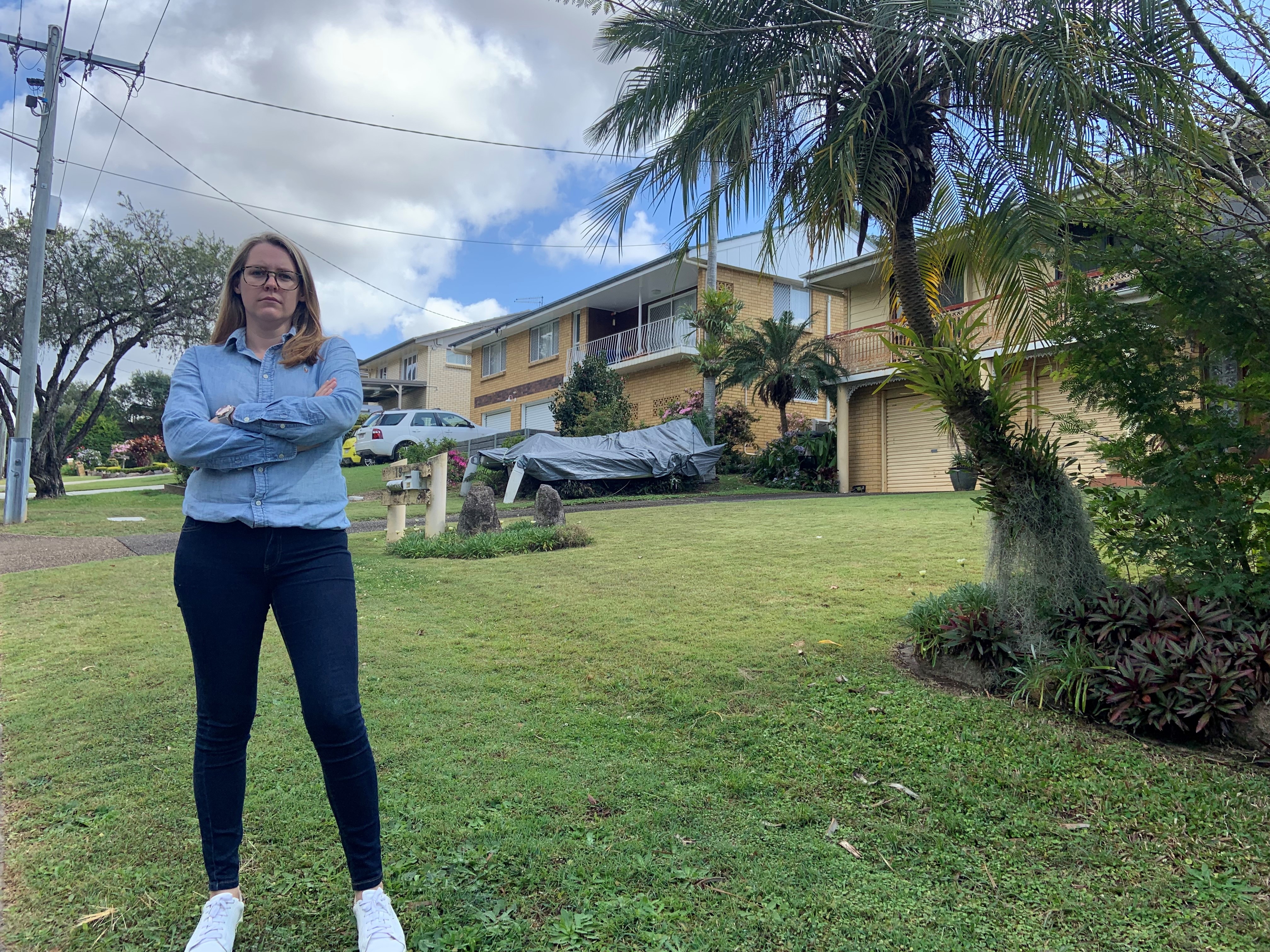 Megan Whiting standing with her arms crossed on the property. She is wearing a blue shirt and jeans.