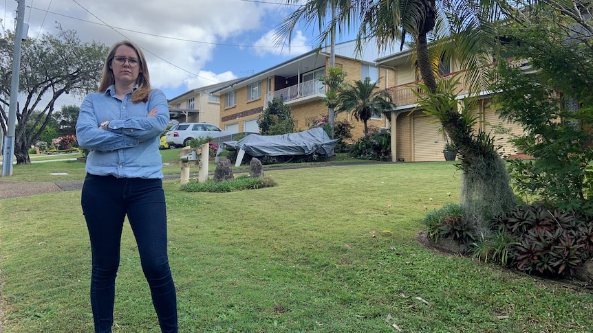 Megan Whiting standing with her arms crossed on the property. She is wearing a blue shirt and jeans.