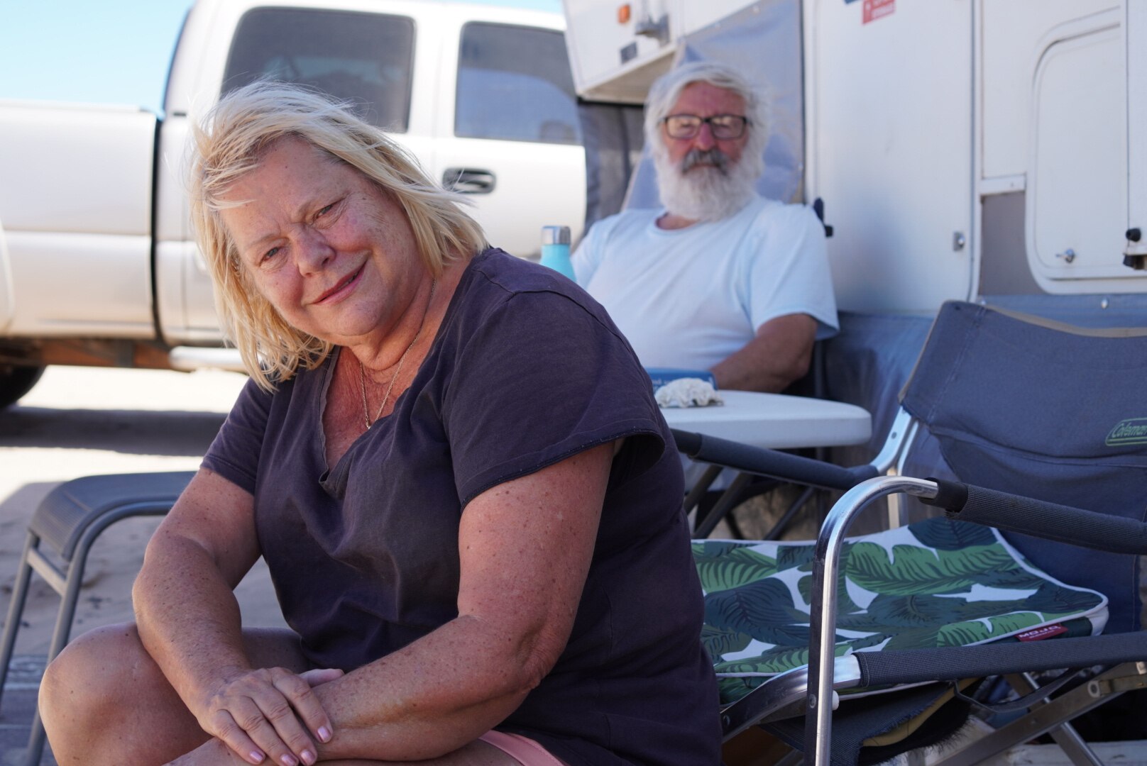 A photo of Anna and Robert Caffrey sitting outside their caravan.