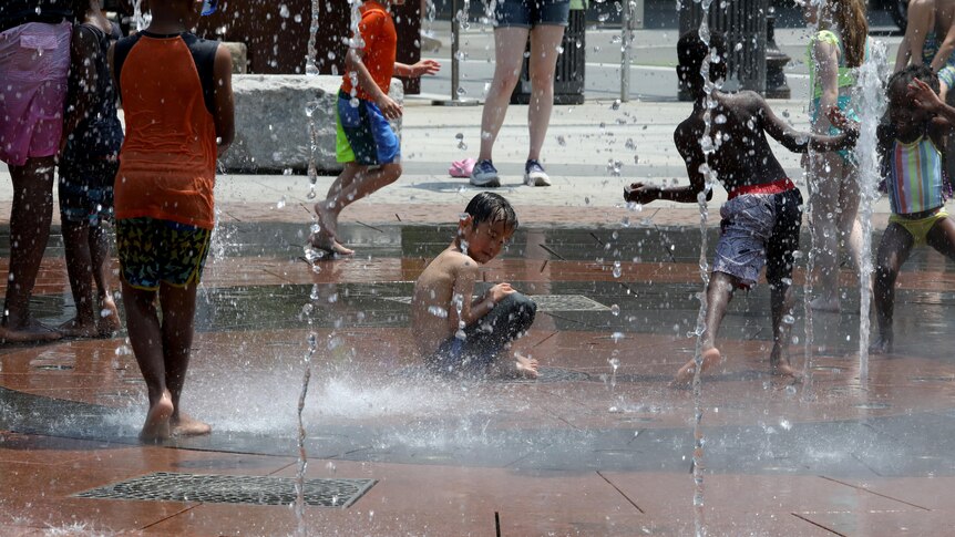 Children play in a city water feature.