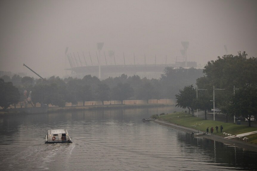 The sky is hazing and grey over the Yarra River and MCG in Melbourne.
