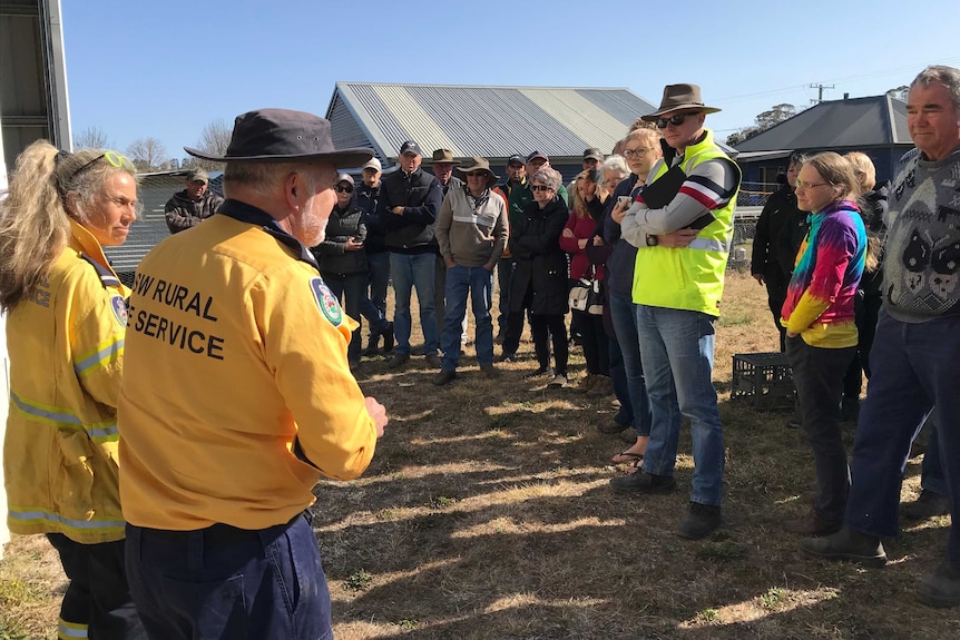 A number of people listening to a rural fire service worker.