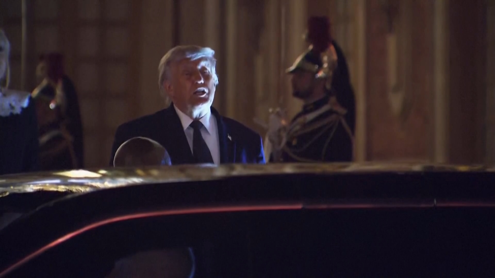 Doanld Trump standing next to a car 