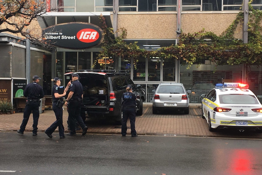Police officers in front of the IGA at Gilbert Street in Adelaide's CBD.