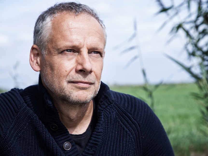 Cellist Pieter Wispelwey in nature gazing into the distance.