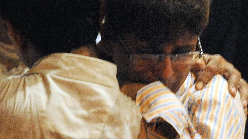 Two people console each other outside a hospital casualty ward in Mumbai.