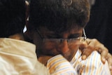 Two people console each other outside a hospital casualty ward in Mumbai.