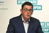 Daniel Andrews gestures and speaks at a press conference.