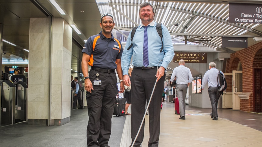 Bashir Embrim speaks to a visually impaired commuter as he makes his way through Brisbane's Central station.