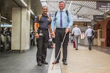 Bashir Embrim speaks to a visually impaired commuter as he makes his way through Brisbane's Central station.