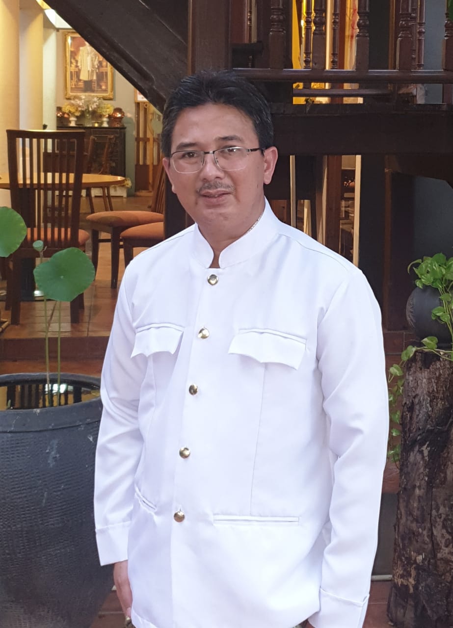 A portrait of Agus Dwi Susanto in a white jacket.