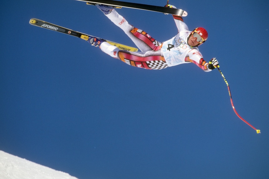 Hermann Maier flies sideways over a hill wearing skis